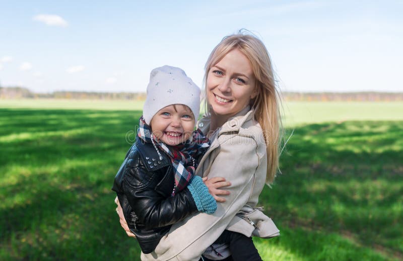Счастливая мать и младенец семьи обнимая на природе летом стоковые изображения